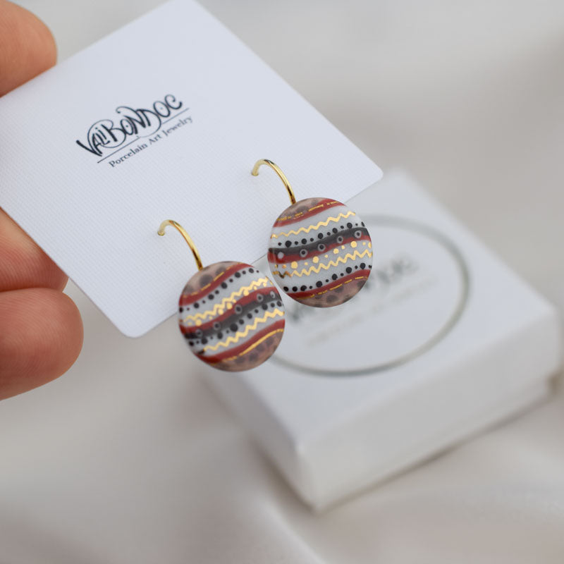 Porcelain hook earrings created and hand-painted by Vali Bondoc with high temperature ceramic dyes and colloidal gold