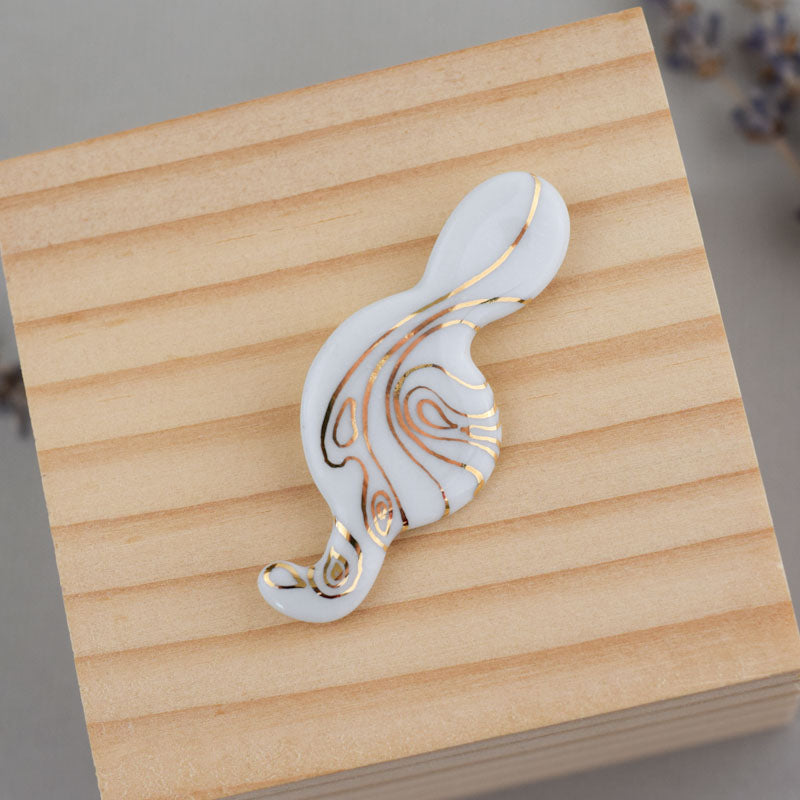 Porcelain brooch created and hand-painted by Vali Bondoc with high temperature ceramic dyes and colloidal gold.