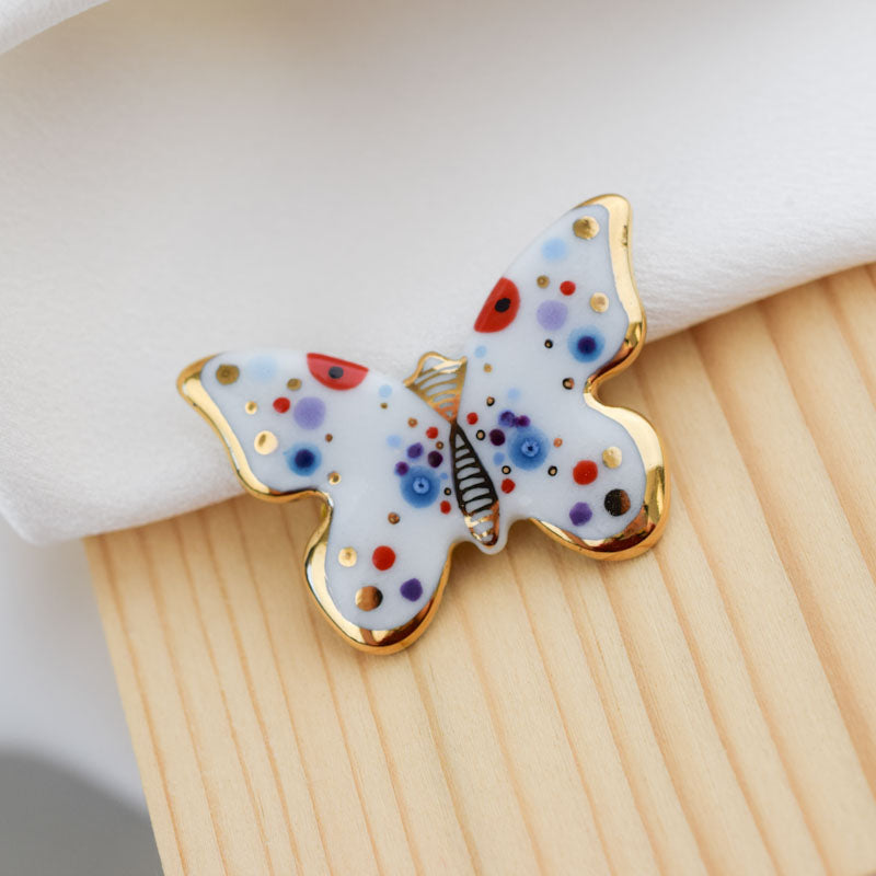 Butterfly. Porcelain brooch created and hand-painted by Vali Bondoc with high temperature ceramic dyes and colloidal gold