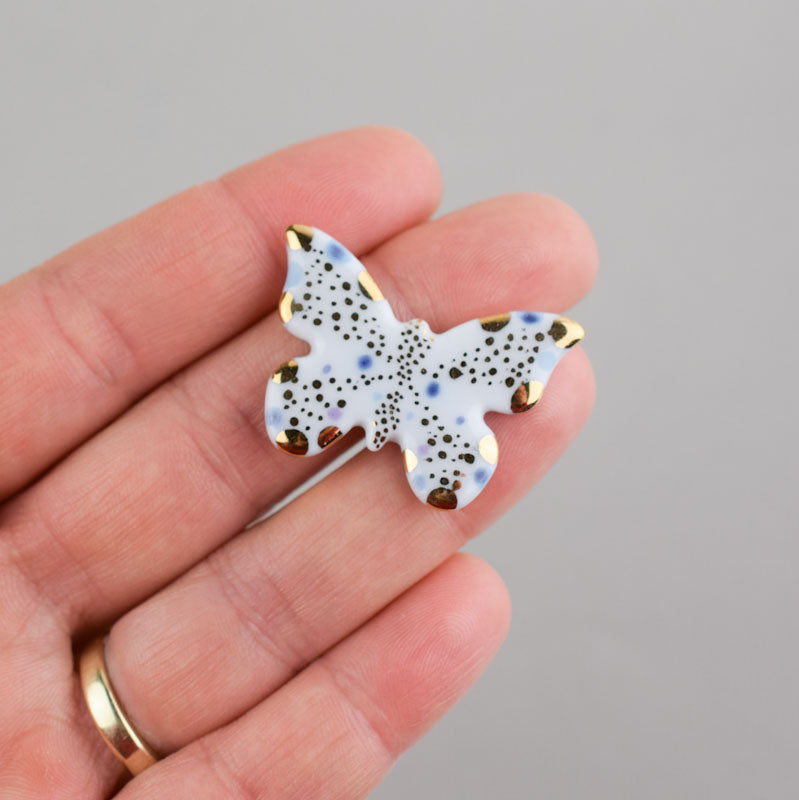 Butterfly. Porcelain brooch created and hand-painted by Vali Bondoc with high temperature ceramic dyes and colloidal gold