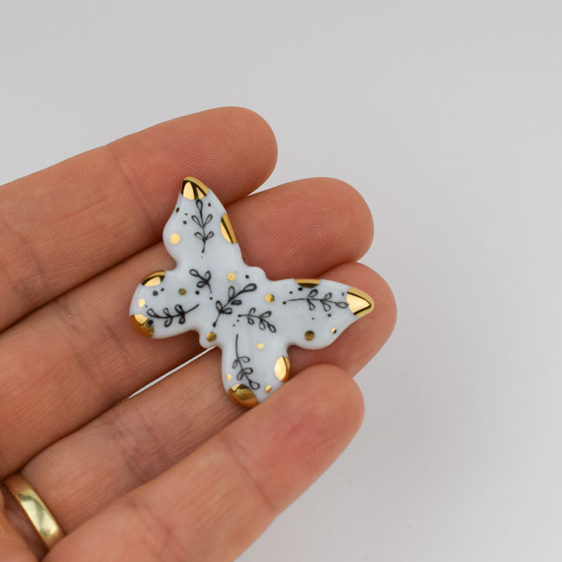 Porcelain brooch created and hand-painted by Vali Bondoc with high temperature ceramic dyes and colloidal gold.
