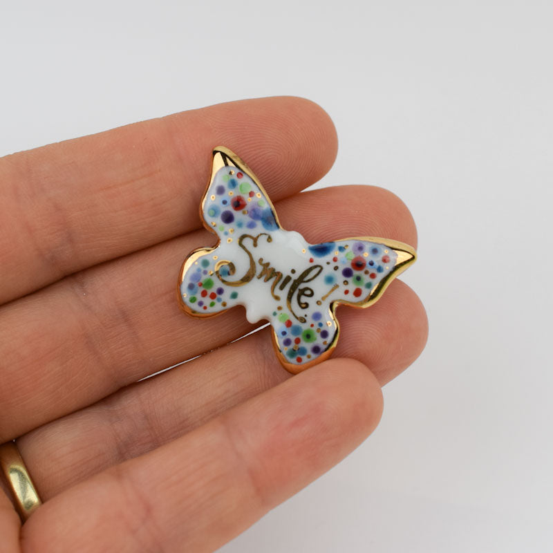 Porcelain brooch created and hand-painted by Vali Bondoc with high temperature ceramic dyes and colloidal gold.