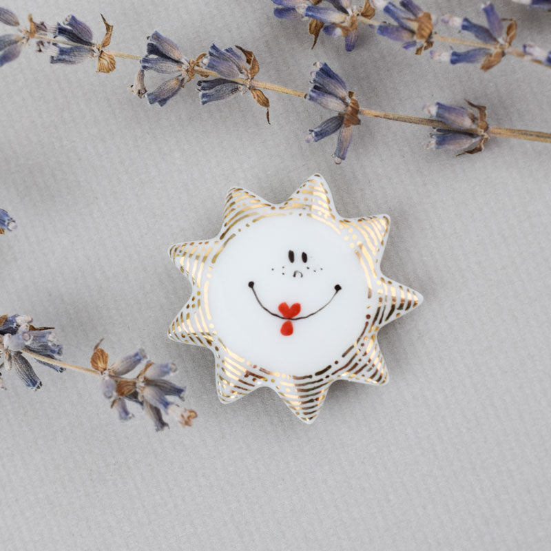 Sun. Porcelain brooch created and hand-painted by Vali Bondoc with high temperature ceramic dyes and colloidal gold.