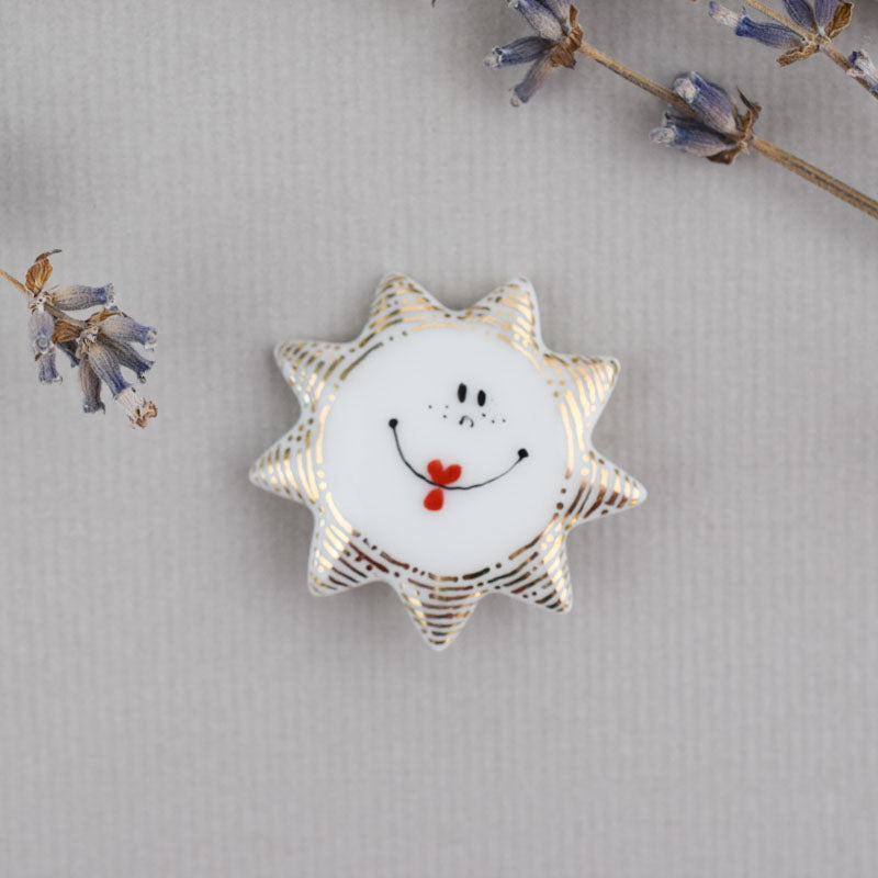 Sun. Porcelain brooch created and hand-painted by Vali Bondoc with high temperature ceramic dyes and colloidal gold.