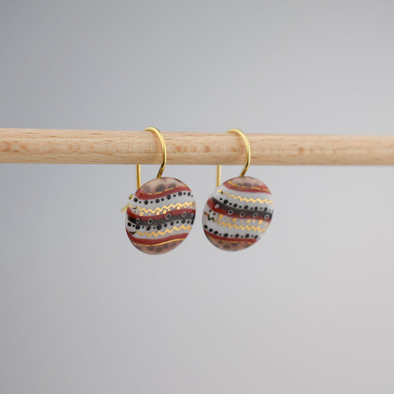 Porcelain hook earrings created and hand-painted by Vali Bondoc with high temperature ceramic dyes and colloidal gold