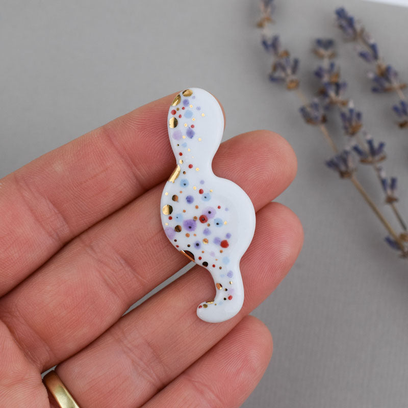 Porcelain brooch created and hand-painted by Vali Bondoc with high temperature ceramic dyes and colloidal gold.