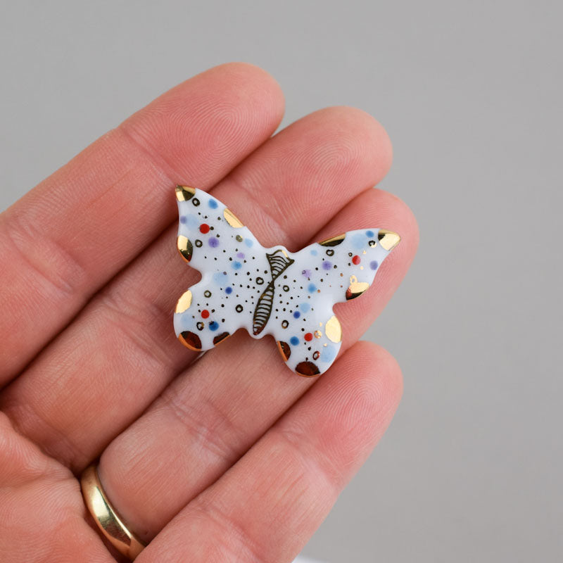 Butterfly. Porcelain brooch created and hand-painted by Vali Bondoc with high temperature ceramic dyes and colloidal gold