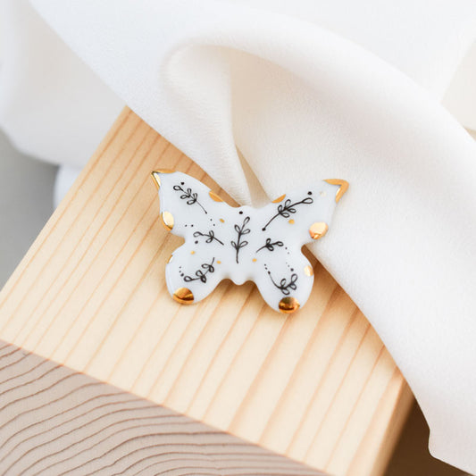 Porcelain brooch created and hand-painted by Vali Bondoc with high temperature ceramic dyes and colloidal gold.