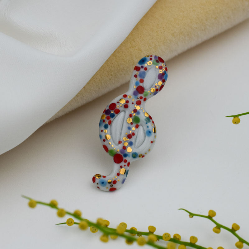 Treble Clef. Porcelain brooch created and hand-painted by Vali Bondoc with high temperature ceramic dyes and colloidal gold.